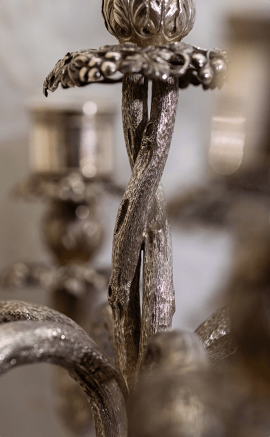 Close-up detail of an antique silver candelabrum showcasing Jewish heritage craftsmanship.