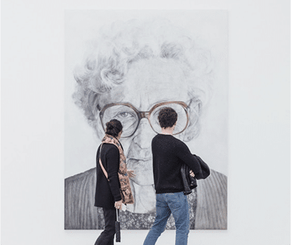 Visitors at the Jewish Museum Curaçao admiring a large portrait reflecting Jewish identity and heritage.