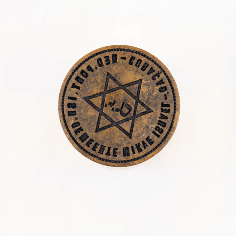 Vintage stamp featuring a Star of David and Hebrew script, part of the synagogue collection at the Jewish Museum in Curaçao.