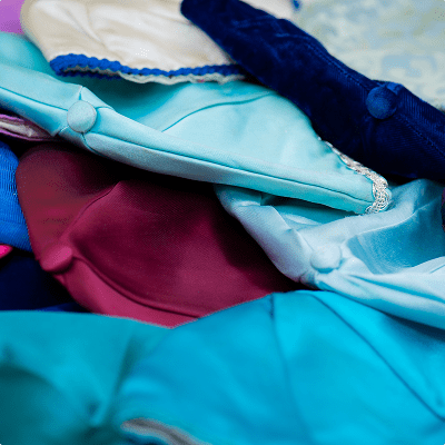 Pile of colorful kippahs in different shades of blue and purple.